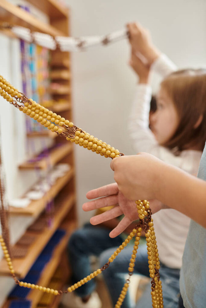 gyerek számolás sárga gyöngyök, Montessori iskola koncepció, gyermekkor, oktatás, matematika, kíváncsiság, tanulmány - Fotó, kép