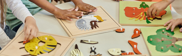 teilweise Ansicht von Kindern, die während des Unterrichts in der Montessori-Schule mit didaktischen Materialien spielen, Banner - Foto, Bild