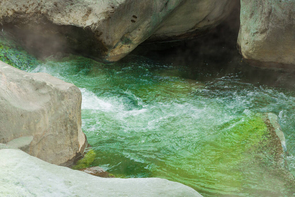 Közelkép egy meleg forrás patak, A víz élénk zöld, és úgy tűnik, hogy gyorsan folyik. - Fotó, kép