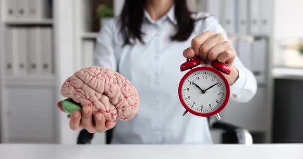 Frau hält roten Wecker und künstliches Gehirn Modell 4k Film Zeitlupe. Schlaf- und Wachzeit-Konzept - Filmmaterial, Video
