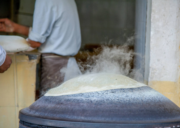 15 grudnia 2021-Piekarz ugniatający poszycie do pieczenia chleba w Jordanie - Zdjęcie, obraz