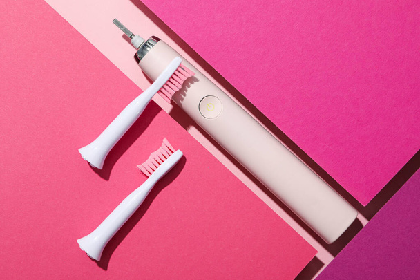 ピンクの背景に電気歯ブラシ,トップビュー - 写真・画像