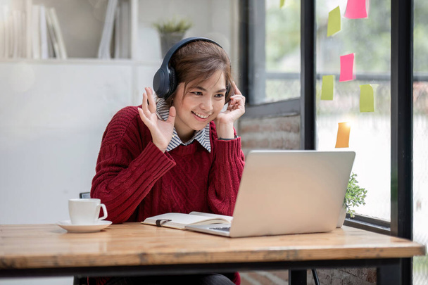 Азіатська студентка вчить онлайн на уроках, вчить онлайн, носить навушники, дивиться відео виклик, збільшує, щаслива азіатська жінка вивчає мову онлайн з комп'ютерним ноутбуком - Фото, зображення