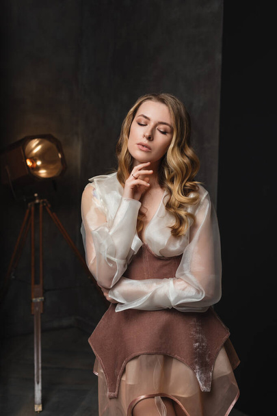sexy young woman in the vintage studio, fashion blonde model in a stylish dress - Фото, изображение