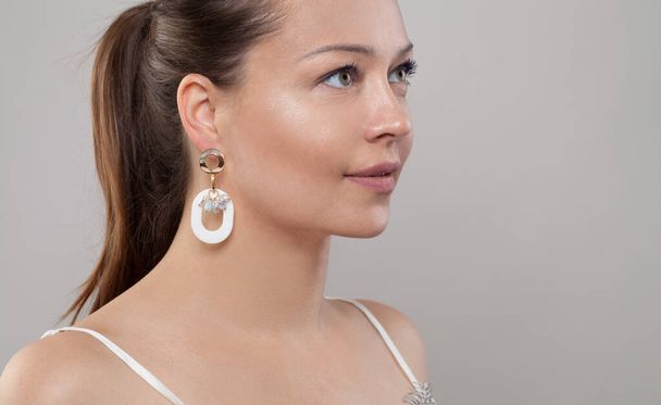 Bijou earring with beads on ear of beautiful brunette woman closeup - Photo, Image