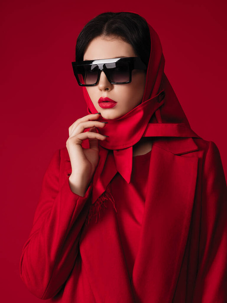 Teljes piros divat modell kabátban és fejkendőben. Stúdió fotózás márkás ruhák. Barna nő alkalmi ruhában. - Fotó, kép