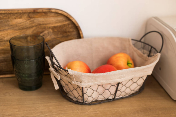 basket with fresh fruits on wooden table in kitchen - 写真・画像