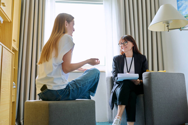 Female psychologist therapist working with young teen girl sitting in office. Teenage female student at therapy meeting with counselor. Psychology therapy psychotherapy youth mental health treatment - 写真・画像