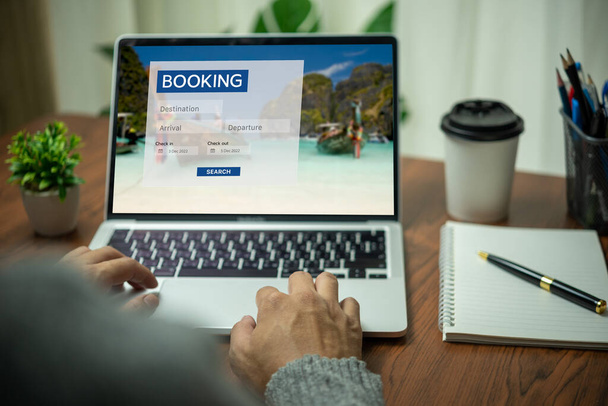 Online-Buchungsplattform auf einem Laptop von einer Person. Man nutzt Webseiten, um nach Unterkünften, Hotels und Fluggesellschaften für ihre Urlaubsreisen zu suchen oder Touren im Internet zu kaufen. - Foto, Bild