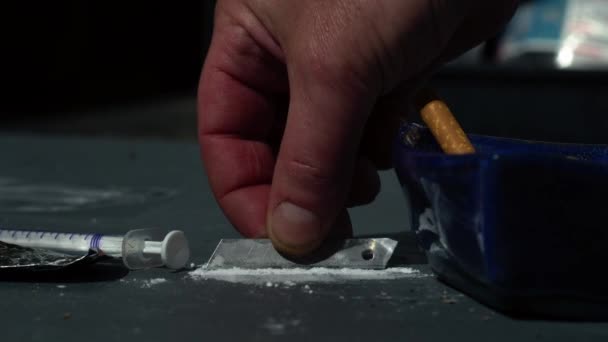 Narkoman przygotowuje linie kokainy zbliżenie slow motion zoom shot selektywna ostrość - Materiał filmowy, wideo