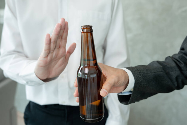 man refuses say no and avoid to drink alcohol at work, stopping hand sign male, alcoholism treatment, alcohol addiction, quit booze, Stop Drinking Alcohol. Refuse Glass liquor, unhealthy, reject - Photo, Image
