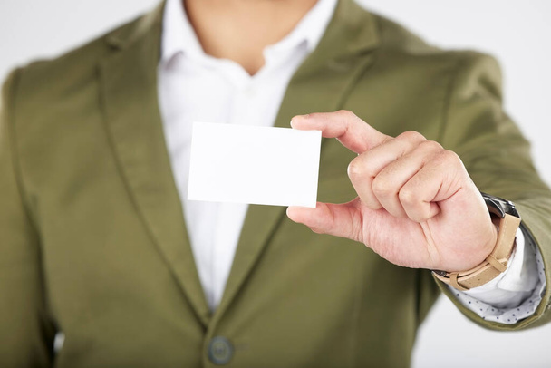 Man, hand and business card in advertising, marketing or branding against a white studio background. Closeup of businessman with paper, poster or sign for contact information or services on mockup. - Photo, Image