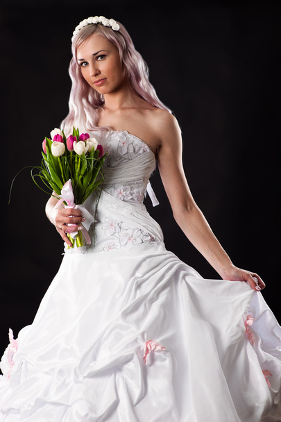 Bride in a wedding dress with a bouquet of tulips - Фото, зображення