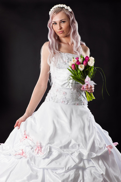 Attractive bride in a wedding dress with a bouquet of tulips - Valokuva, kuva