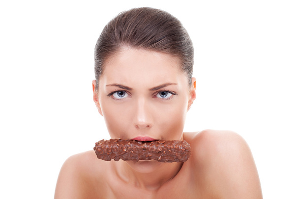 Vakava nainen syö suklaapatukka
 - Valokuva, kuva