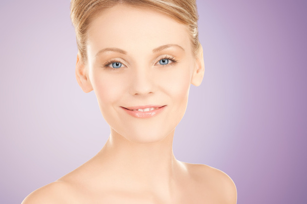 beautiful young woman face over violet background - Photo, Image
