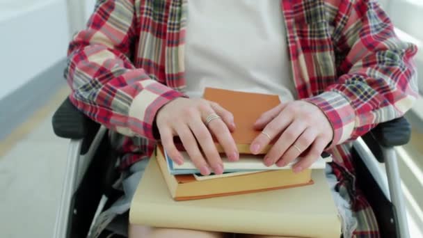 回廊に沿って移動する車椅子に座っている障害のある認識できない女子大学生の中部追跡ショット - 映像、動画