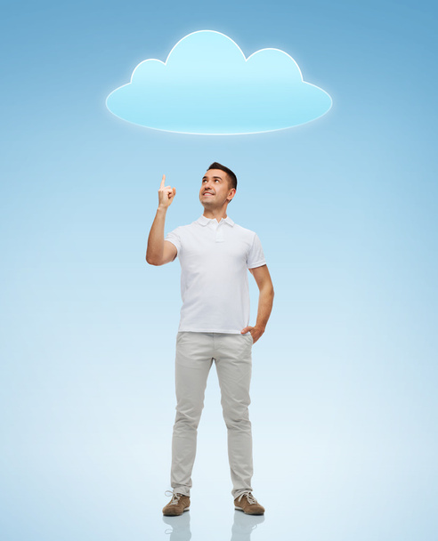 smiling man pointing finger up to cloud - 写真・画像