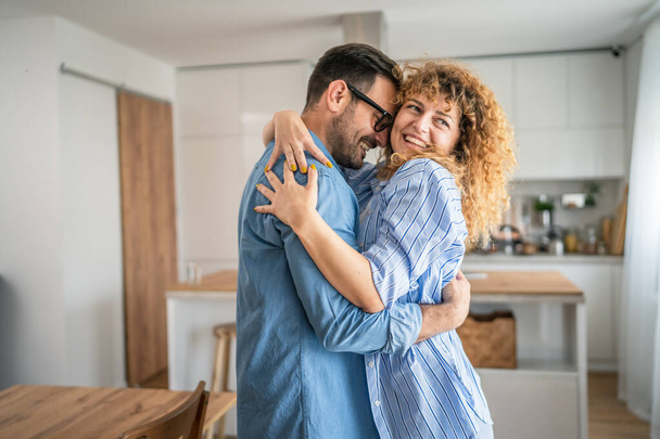 happy caucasian adult couple man and woman at home together smile husband and wife or boyfriend and girlfriend stand have fun - Photo, Image