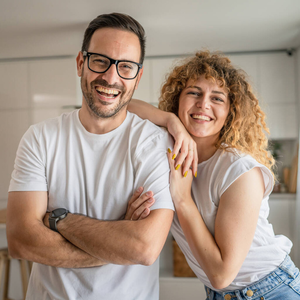 happy caucasian adult couple man and woman at home together smile husband and wife or boyfriend and girlfriend stand have fun - Photo, Image