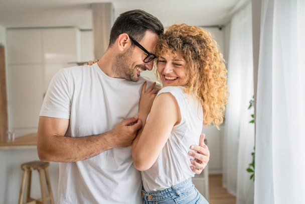 счастливая белая взрослая пара мужчина и женщина дома вместе улыбаются муж и жена или парень и девушка стоять весело - Фото, изображение