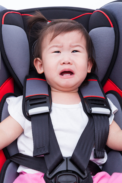 Fille pleurer au siège auto et attacher la ceinture de sécurité
 - Photo, image