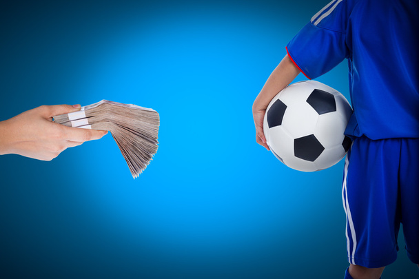 Οπίσθια όψη της νεολαίας ποδοσφαιριστής και χέρι που κρατά στοίβες της Τράπεζας - Φωτογραφία, εικόνα