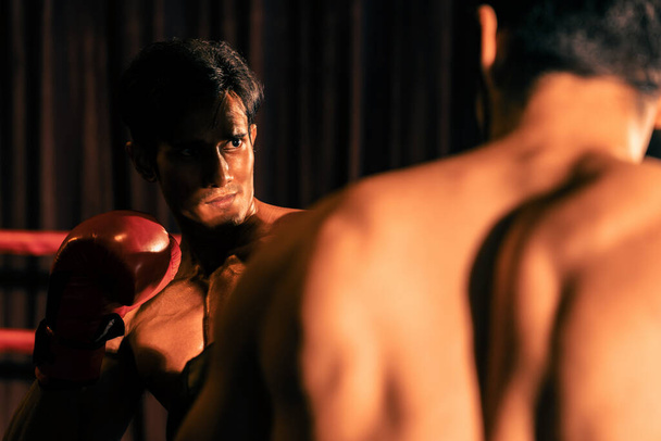 Le boxeur asiatique et caucasien Muay Thai libère son pouvoir dans un match de boxe féroce. boxer thaïlandais avec un corps musclé fort échangeant poinçon et frapper avec des prouesses de combat implacables. Impulsion - Photo, image