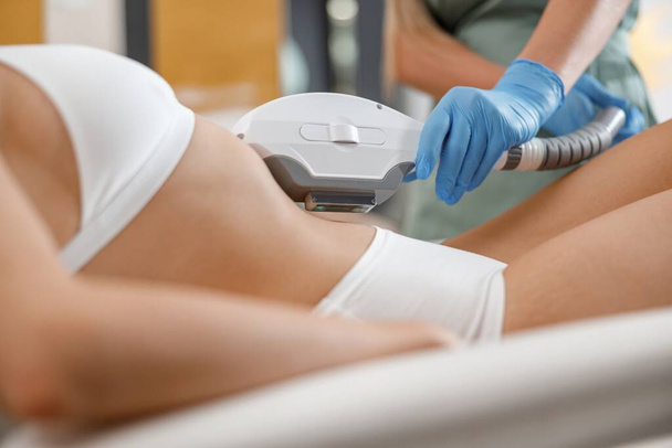 Zbliżenie młodej kobiety otrzymującej depilację laserową maszyną ipl w centrum urody. Usuwanie włosów - Zdjęcie, obraz