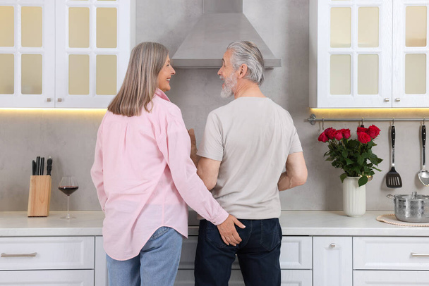 Affectionate senior couple spending time together in kitchen - Fotografie, Obrázek