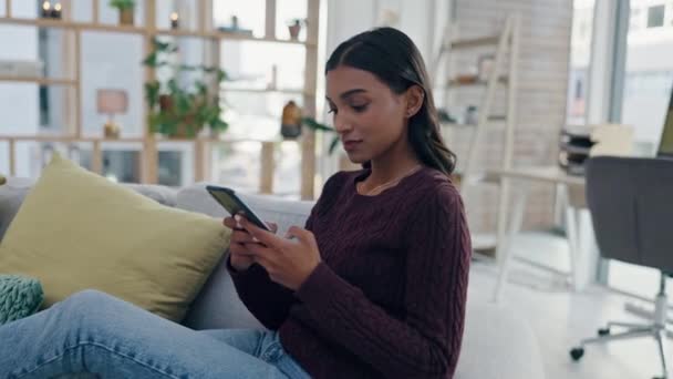 Woman, sofa and typing on her phone for social media, communication and networking or job search. Young person relax on couch and chat on mobile for work from home, contact or freelancer opportunity. - Filmati, video