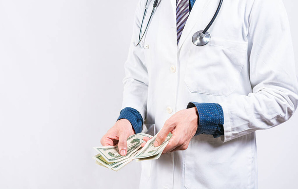 Yozlaşmış doktor izole edilmiş paraları sayıyor. Yozlaşmış doktorun elleri izole edilmiş geçmişe para sayıyor, tıbbi yozlaşma kavramı - Fotoğraf, Görsel
