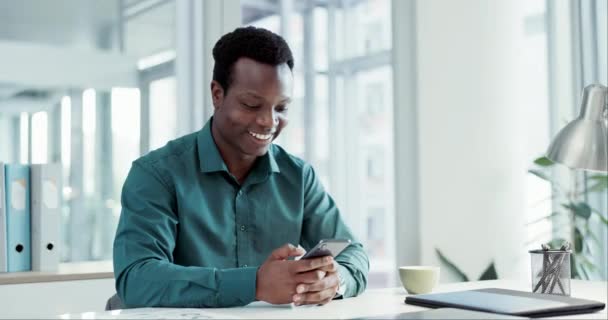 Hombre de negocios, mensaje de teléfono divertido y escritorio con una sonrisa de las redes sociales y la creación de redes en el trabajo. Feliz, Africano profesional masculino y empleado aplicación web meme con la comunicación en línea y la planificación. - Imágenes, Vídeo