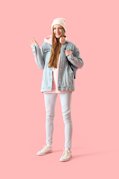 Nő diák integető kéz rózsaszín háttér - Fotó, kép