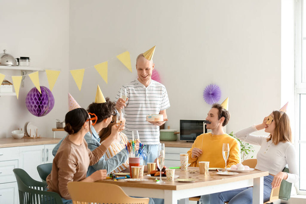 Grupa młodych przyjaciół świętuje urodziny w kuchni - Zdjęcie, obraz