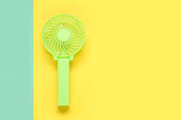Small green electric fan on color background - Photo, Image