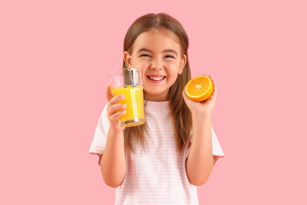 Aranyos kislány egy pohár gyümölcslé és narancs színben háttér - Fotó, kép