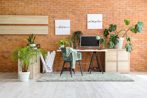 Інтер'єр стильного офісу з сучасним робочим місцем, стелажами і кімнатними рослинами - Фото, зображення
