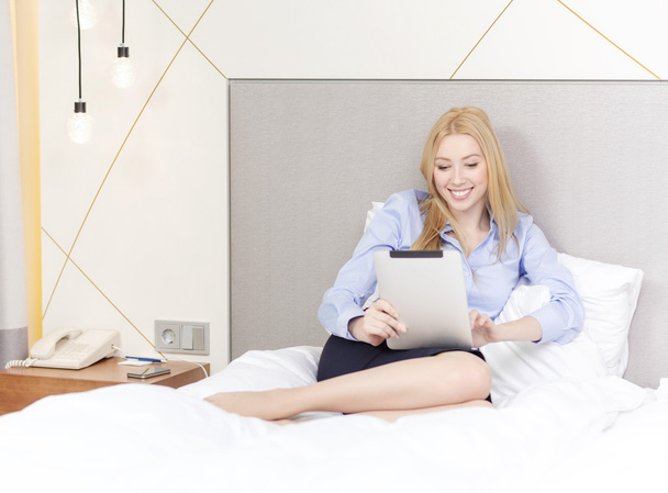 happy businesswoman with tablet pc in hotel room - Фото, зображення