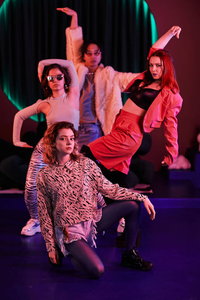 Κάθετη ολόσωμη προσωπογραφία του vogue dance crew ποζάρει σε ροζ νέον φως - Φωτογραφία, εικόνα