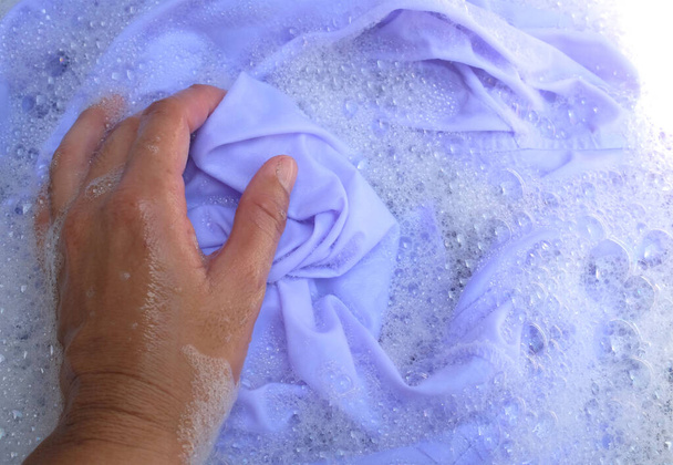 Ręka azjatyckiej gospodyni domowej pranie białych ubrań, mundur szkolny, mundury studenckie z detergentem bąbelkowym w umywalce.Koncepcja pralni - Zdjęcie, obraz
