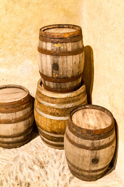 Μια στοίβα από παλιά ξύλινα βαρέλια κρασιού. . - Φωτογραφία, εικόνα