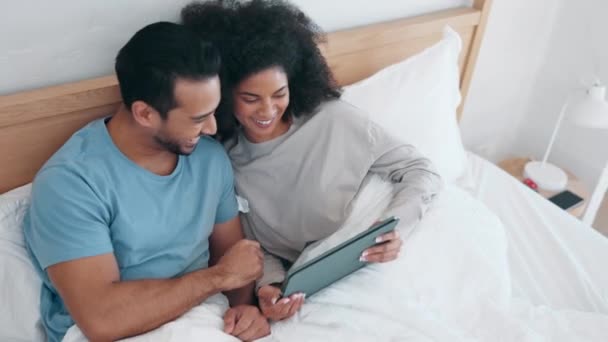 タブレット,ビデオ,そして朝に一緒にベッドでカップルと笑って,自宅でリラックスします. テクノロジー,ソーシャルメディア,またはアパートの寝室で映画を見ている男女のアプリ. - 映像、動画