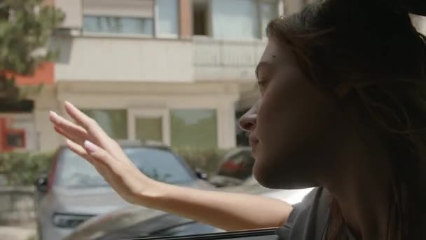 Découvrez la magie de l'exploration urbaine dans ce clip vidéo évocateur. Tournée en gros plan, la scène se déroule avec une jeune femme penchée par la fenêtre d'une voiture, les doigts tendus dans la voiture. - Séquence, vidéo
