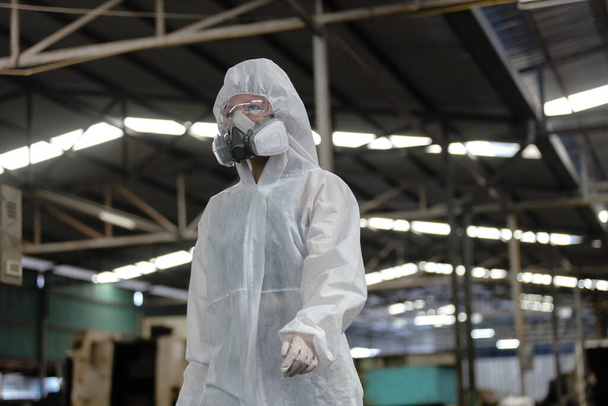 Inspector químico mujer trabajadora que usa máscara protectora y traje de materiales peligrosos examinando química en la industria. Análisis de sustancias nocivas para el cuerpo humano y el medio ambiente. - Foto, imagen