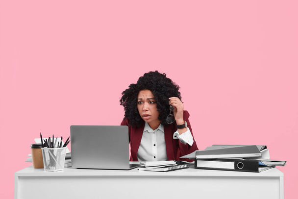 Stressful deadline. Scared woman looking at laptop at white desk on pink background - 写真・画像