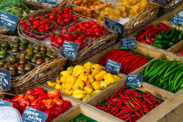 Diverse verse groenten gepresenteerd in manden te koop op een markt. - Foto, afbeelding