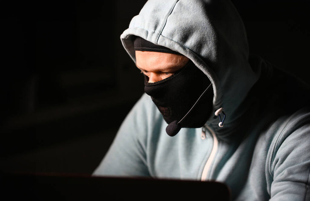 Man carder in mask connect to darknet search information bank system pc crack dark web uses stolen credit card cloud buy illegal services - Photo, Image