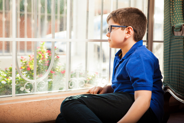Rapaz sentado à frente de uma janela
 - Foto, Imagem