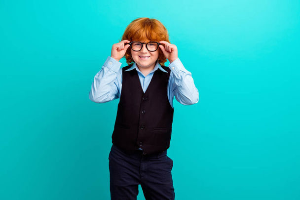 Portrait of cheerful smart small schoolkid toothy smile hands touch eyeglasses isolated on turquoise color background. - Foto, Bild
